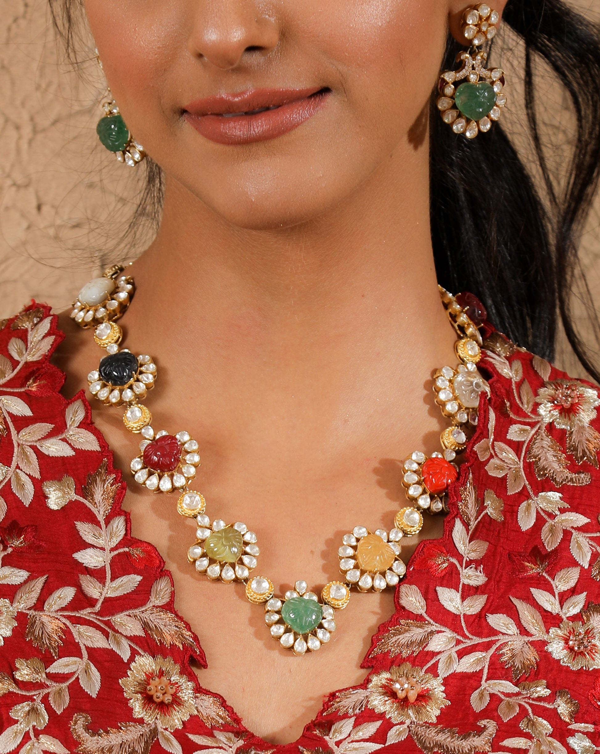 Featuring an 18kt gold plated silver polki necklace set with multicolor carved ston