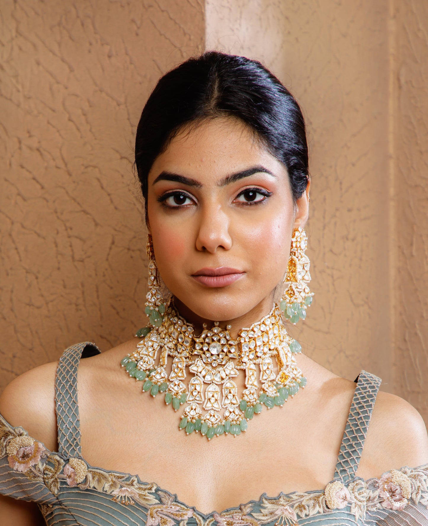 Featuring an 18kt gold plated 92.5 silver Vellore polki heavy choker set with green carved drops & fresh water pearls.