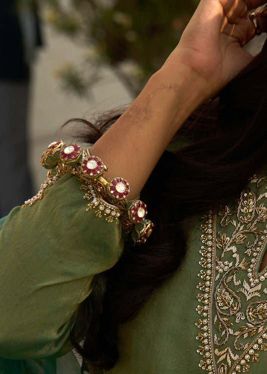 Close-up of a hand wearing a decorative bracelet on a person in traditional attire.