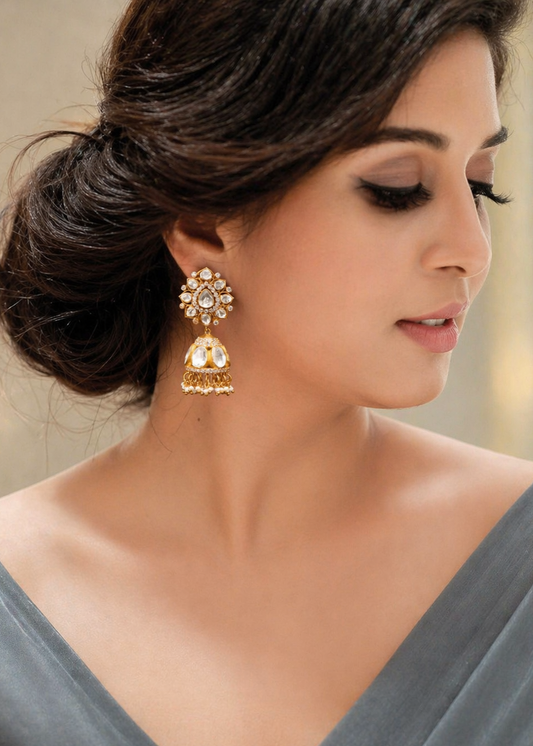 Woman wearing gold earrings with a neutral background