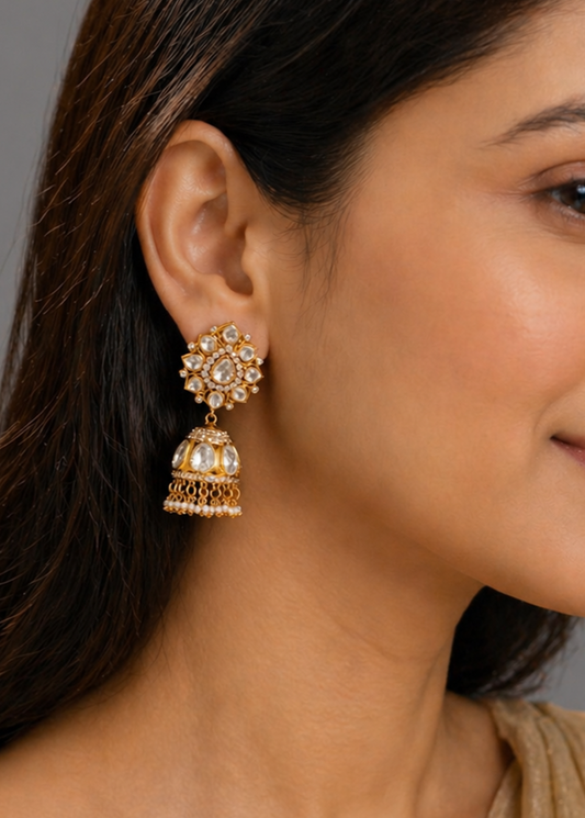 Woman wearing gold earrings with a neutral background